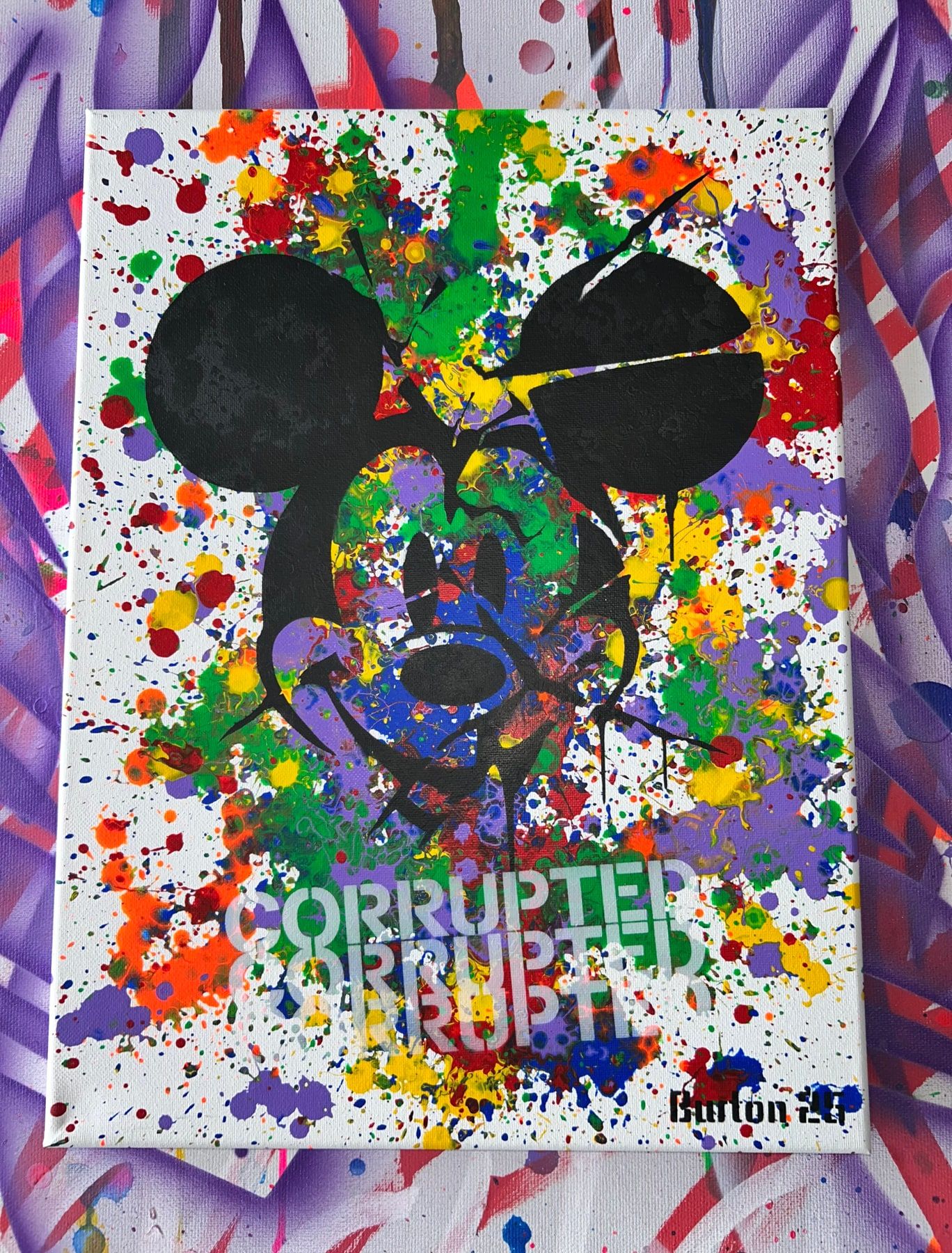 Mickey Mouse stencil in black over rainbow paint splatter on white, with faint Corrupted lettering.