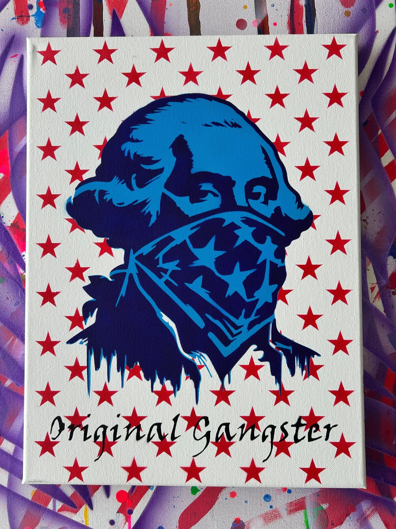 Stencil of George Washington in an American-flag bandana, blue on a red-star background, titled Original Gangster.