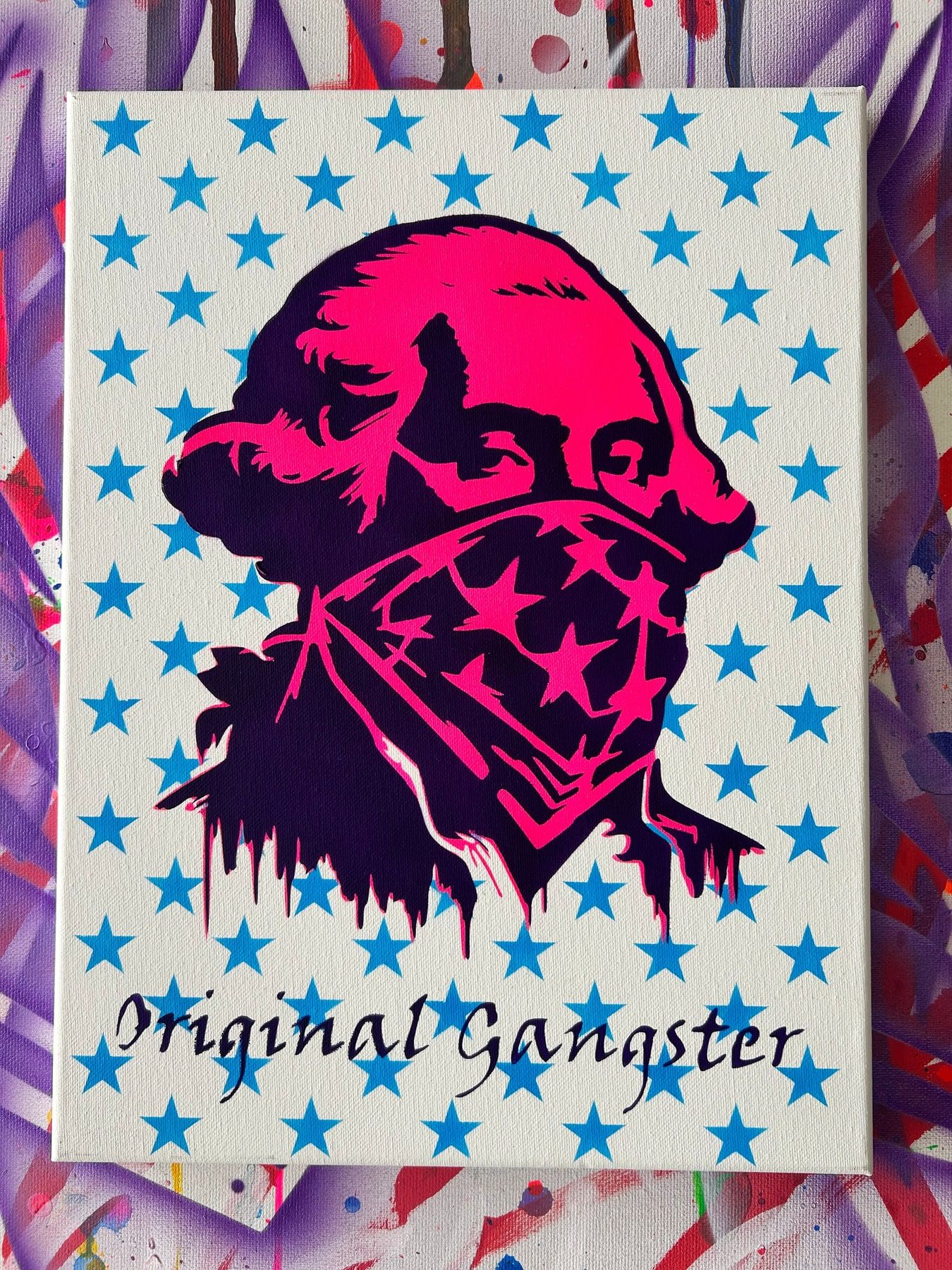 Stencil of George Washington in an American-flag bandana, neon pink on a blue-star background, titled Original Gangster.