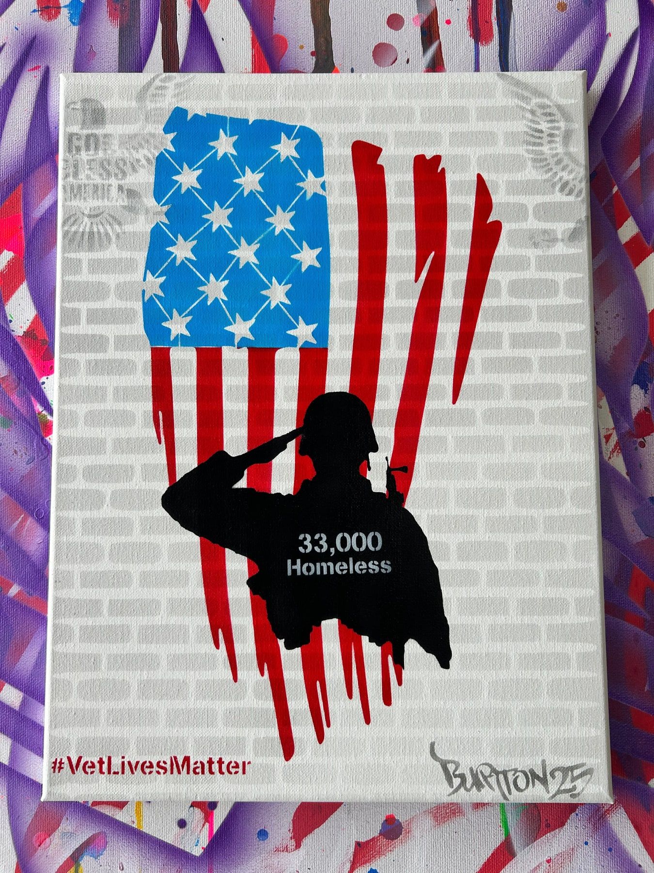 Stencil of a saluting soldier over an American flag, captioned 33,000 Homeless, with #VetLivesMatter.