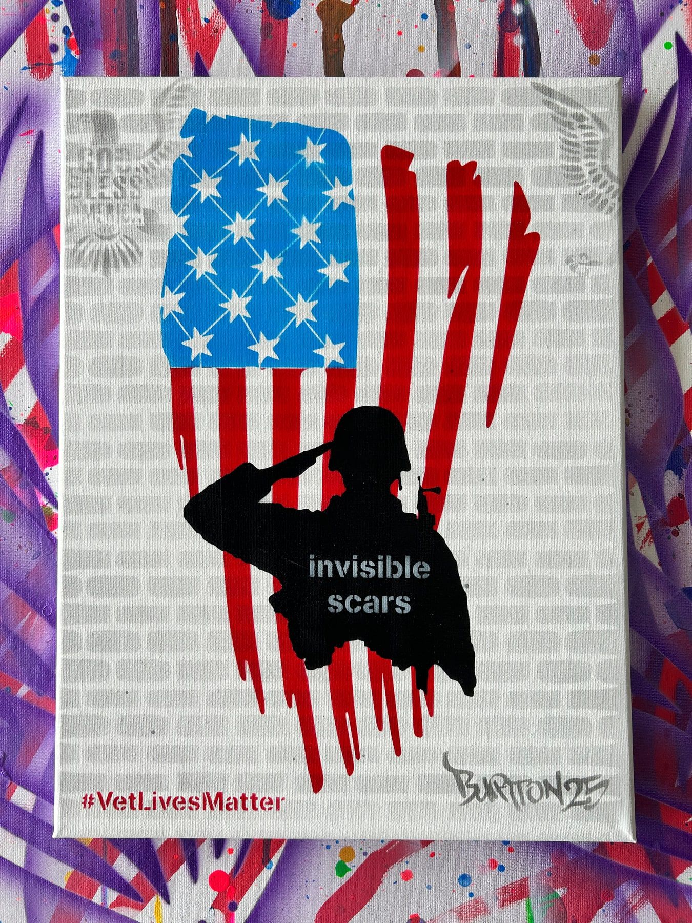 Stencil of a kneeling service member over an American flag, captioned Invisible Scars, with #VetLivesMatter.