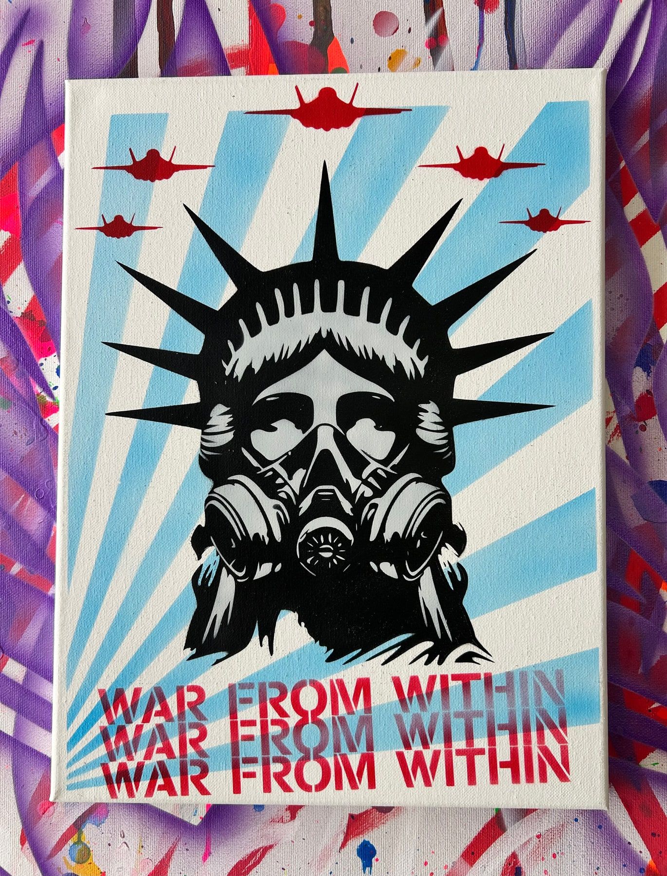 Stencil of the Statue of Liberty in a gas mask with fighter planes overhead on a blue starburst, titled War From Within.